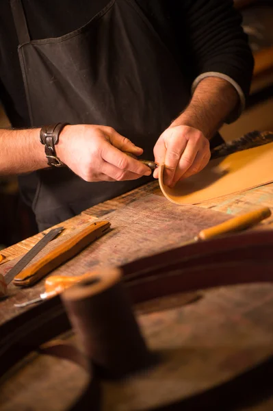 Leather goods craftsman at work in his workshop