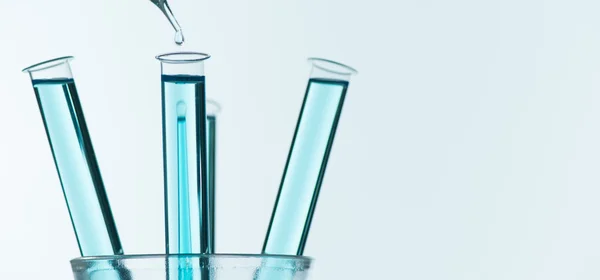 Liquid drop from laboratory glass pipette to test tube