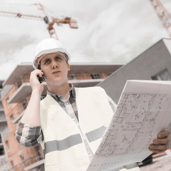 Construction manager checking building project on site