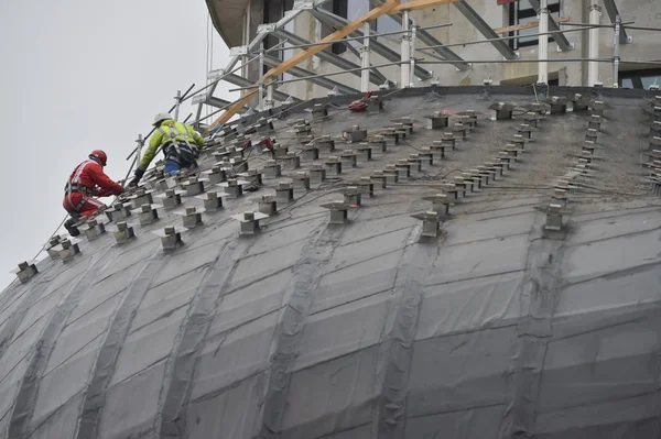 Worker using safety strap on the roof of a bulding under constru