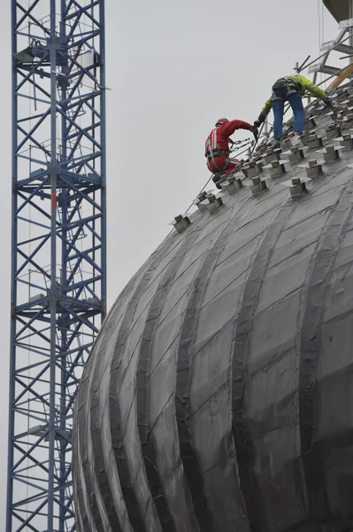 Worker using safety strap on the roof of a bulding under constru