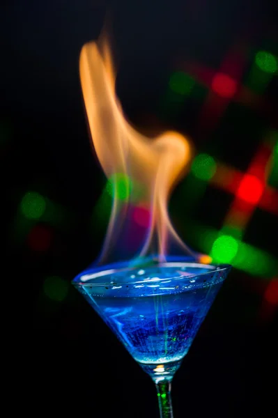 Fire blowing out of blue lagoon glass/close-up with black backgr