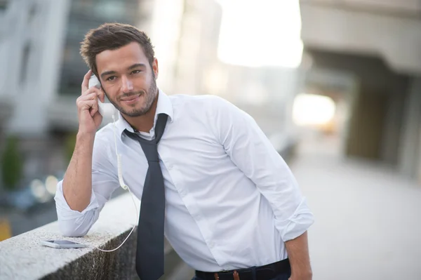 A man using a cell phone with a funny headphone