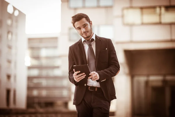 Portrait of a businessman using a tablet.