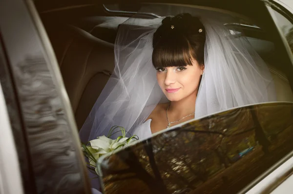 Beautiful bride in wedding limousine