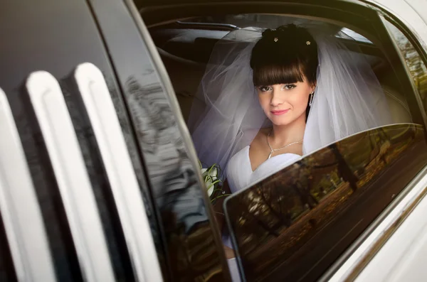 Beautiful bride in wedding limousine