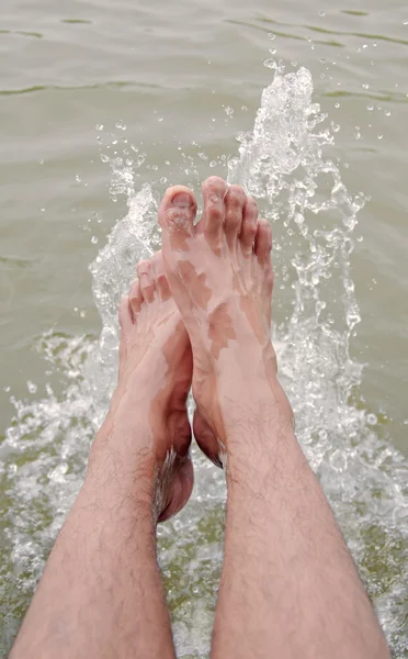 Foot of man in the water splashing