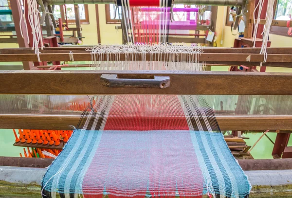 Weaving loom and shuttle on the warp