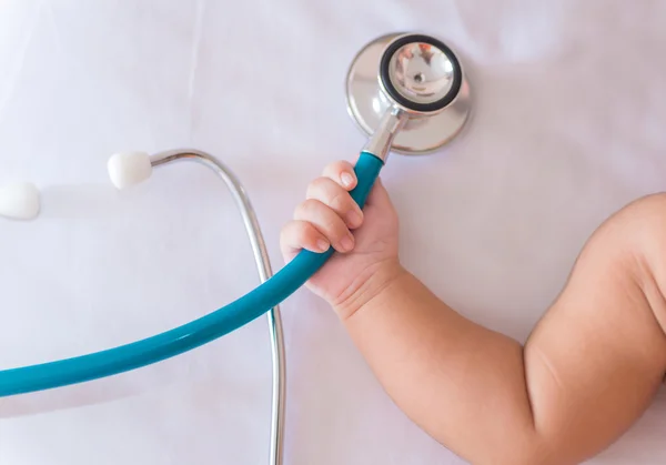 Medical instruments stethoscope in hand of newborn baby girl