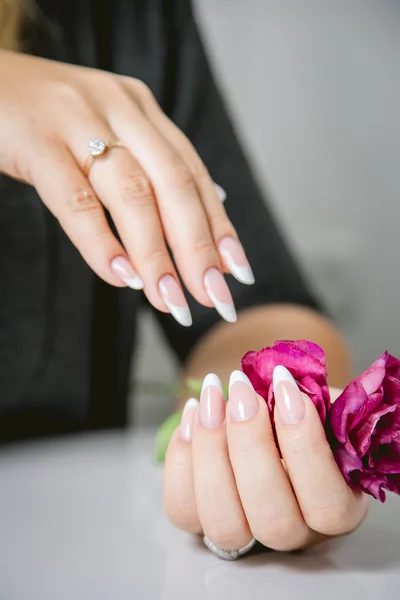 Stylish manicure on a background of flowers, beauty salon
