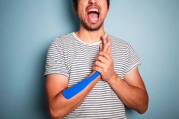 Young man with kinesio tape on his arm