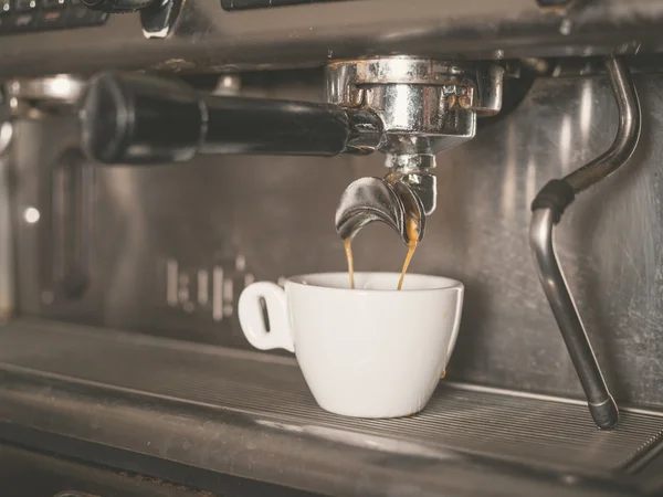 Coffee machine and a small white cup