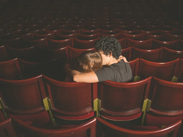 Young couple kissing in movie theater