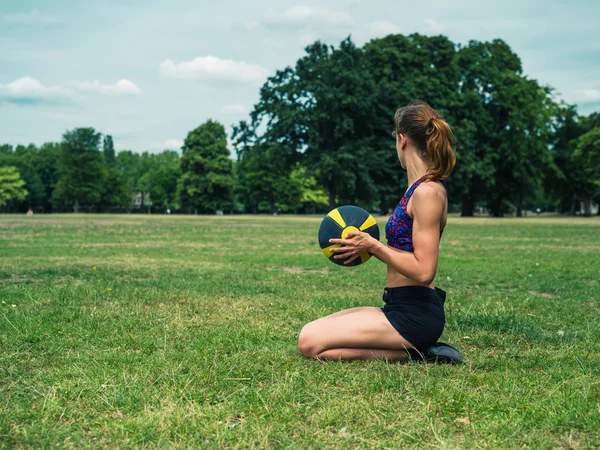 Woman in park with medicine ball