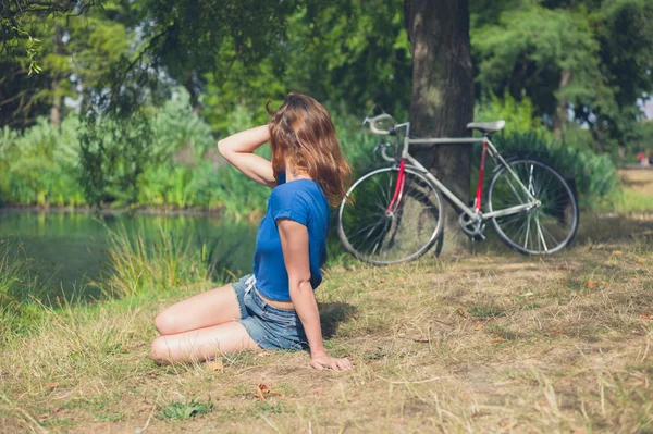 Young woman relaxing by water in the park