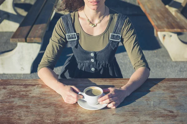 Young woman drinking coffee outside
