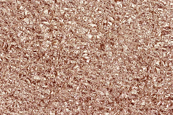 Shiny foil texture for background. Rose gold color. Crease