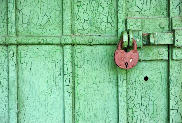 Old lock on the green wooden door