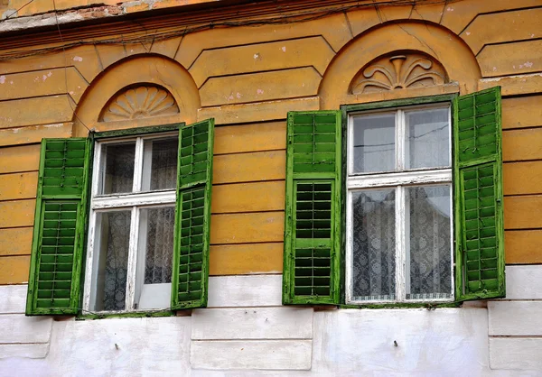 Open wooden windows with the green blinds