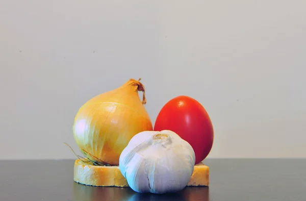 Garlic, onion and tomato on the table