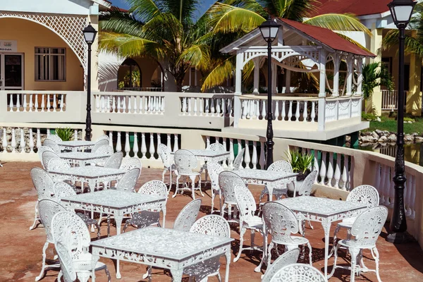 Gorgeous inviting view of Memories resort landscape, outdoor cafe, patio with metal vintage retro classic chairs at early morning on sunny day