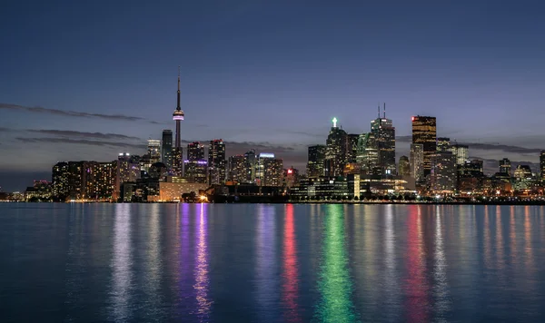 Stunning beautiful Toronto city downtown skyline night view from lake Ontario, against dark blue sky