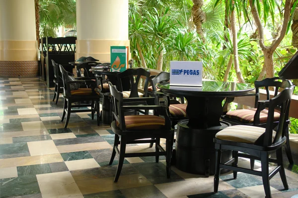 On the table is a plate with logo and inscription Pegas Touristik. Hall Hotel in Pattaya, Thailand