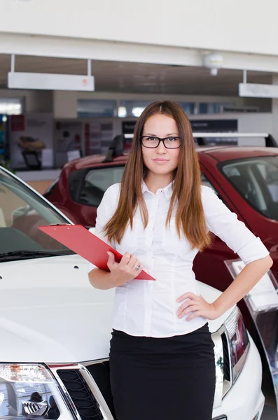 Young woman standing in the showroom with a red folder