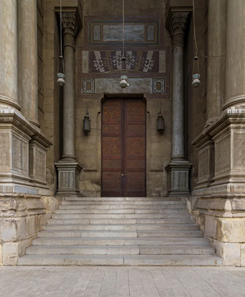 Stairs and wooden door leading to a historic mosque, Cairo