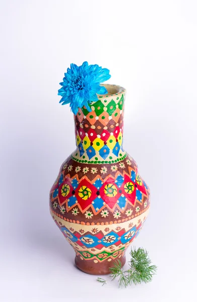 Colorful pottery vase with blue flower on white background