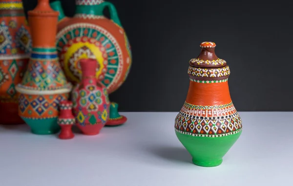 Ornate colorful pottery vase on background of blurred colorful vases