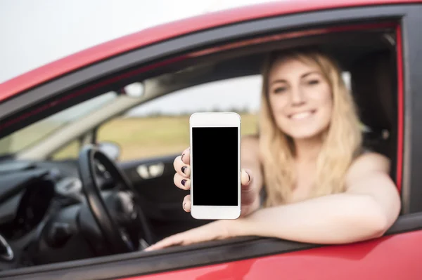 Happy blonde woman showing smartphone.