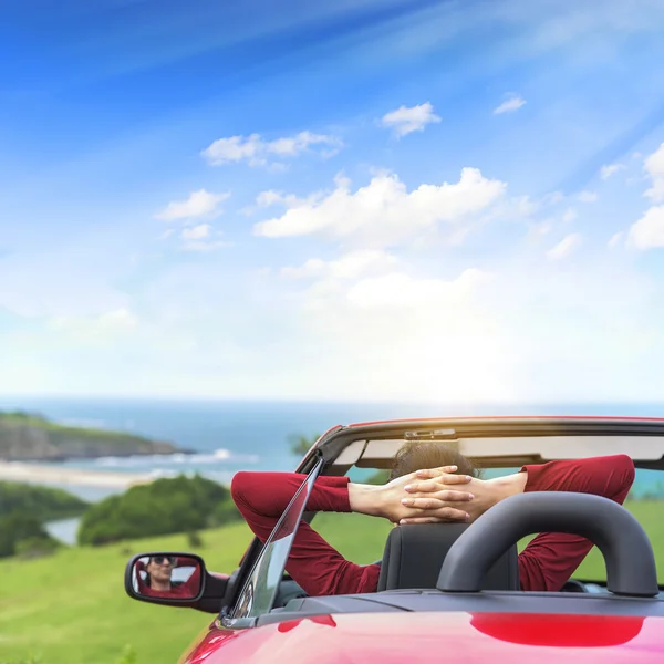 Girl in a red convertible car.