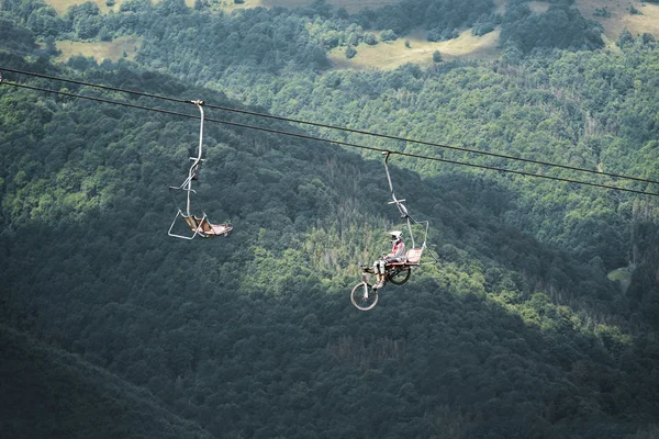 Bicyclist on the elevator lift in the mountains.