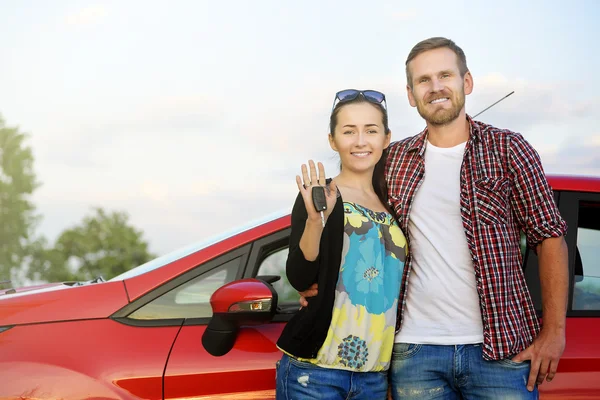 Couple near the red car.