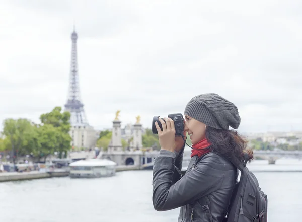 Girl taken pictures Eiffel Tower.