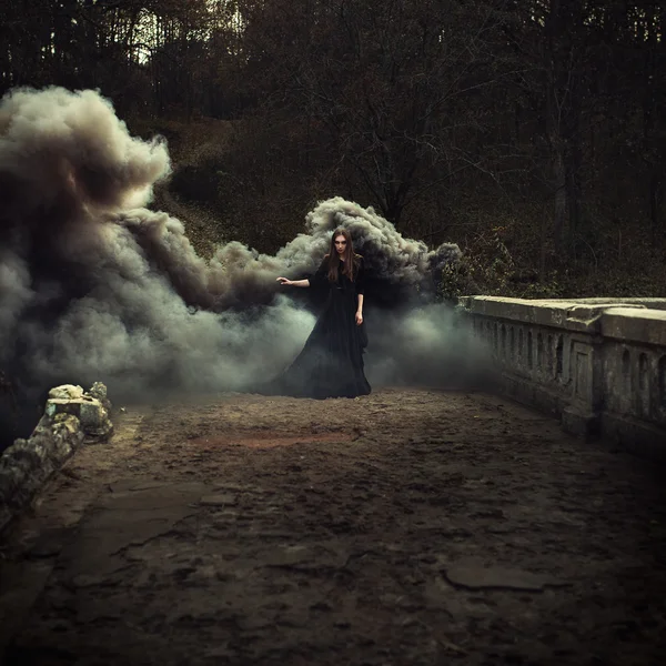 Woman walking on the bridge in heavy black smoke