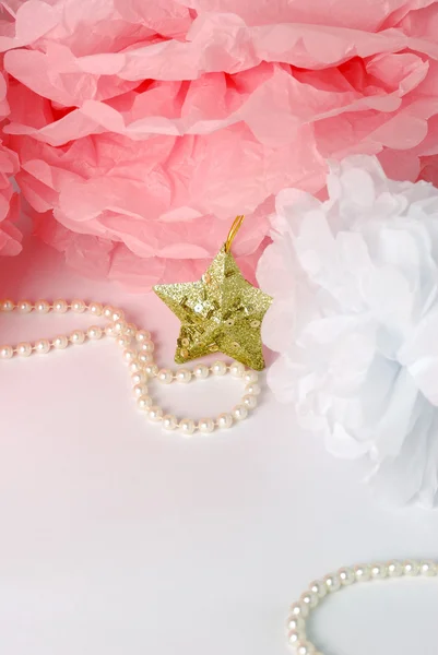 Decorative star, pearl beads and pink and white pom pom.Greeting or invitation card with copyspace