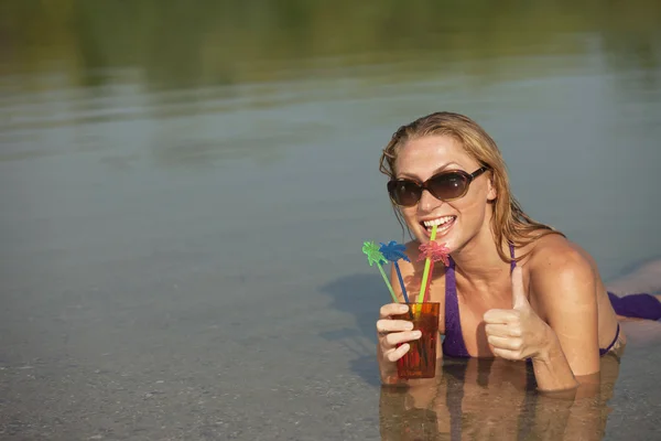 Happy woman with cool drink in the water