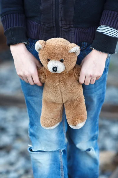 Little homeless boy holding a teddy bear