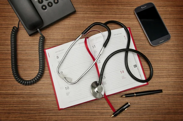 Desk of a medicine doctor. Calendar, phones, stethoscope