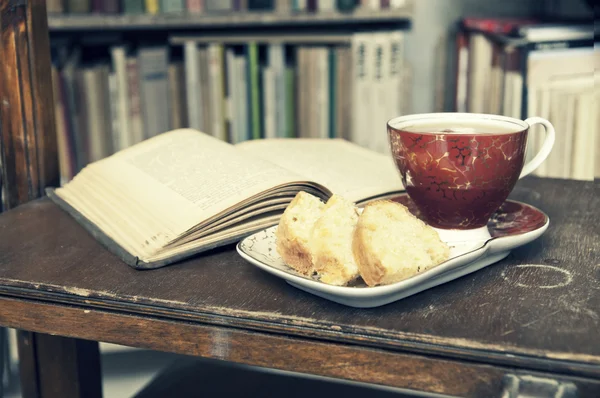 Old book, tea and cake - retro vintage setting