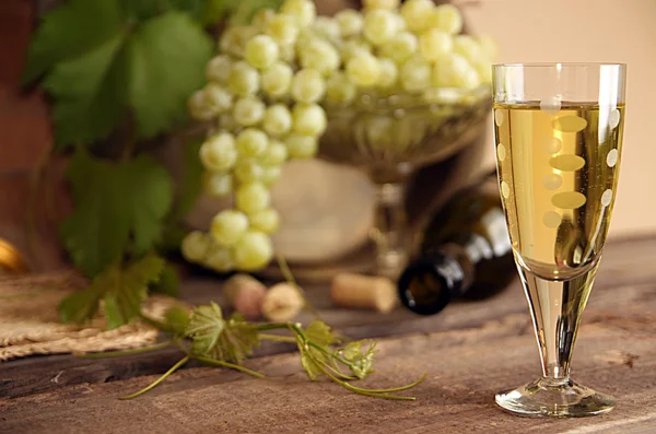 Vintage wine glass against background bunch of grapes and wine b
