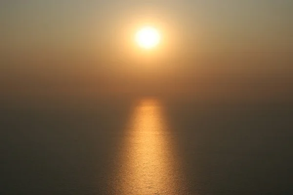 The sun is setting into the sea. On the water visible to the sol