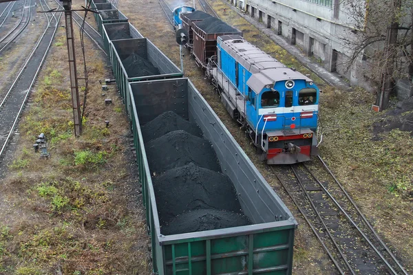 On the rails, two freight trains loaded with coal
