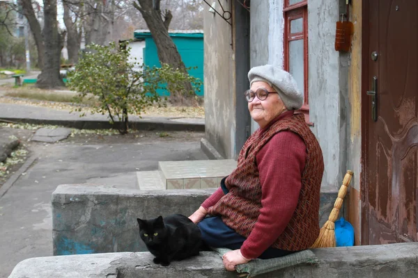 Ukraine. The mountains. 07: 11: 2014 Editorial illustration. Old woman with a cat sitting and waiting when she will bring a pension, social assistance