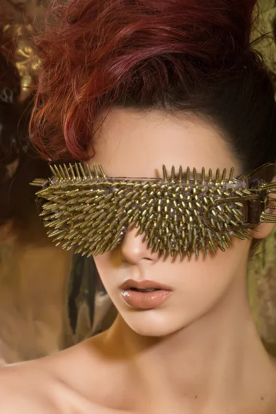 \young girl with red hair wearing glasses with gold spikes in th