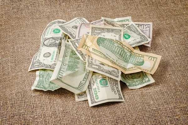 Pile of US dollar banknotes crumpled on jute background