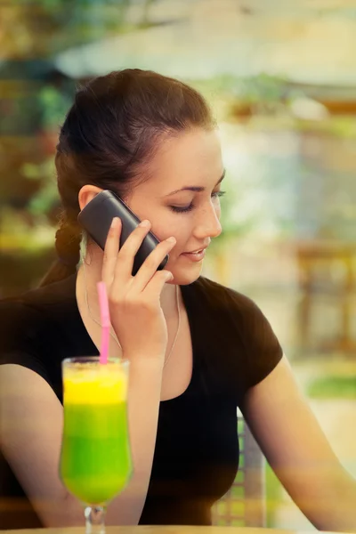 Young Woman with Colorful Cocktail Drink Talking on Her Phone