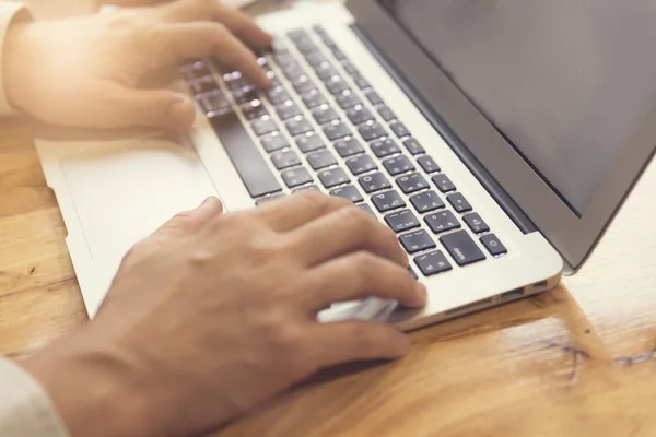 Man\'s hand working with laptop computer notebook, selective focu